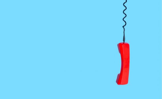 red corded landline telephone against blue background