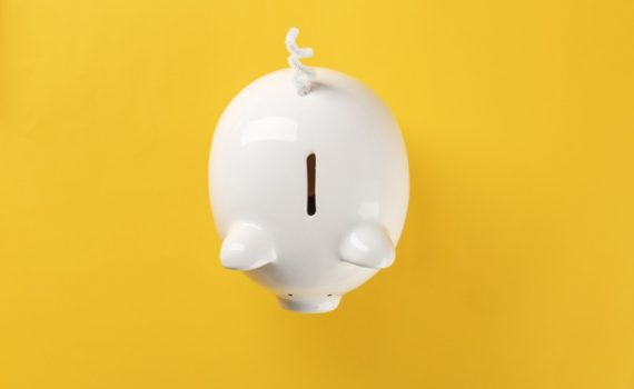 white piggy bank on solid yellow background