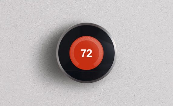 Nest Learning Thermostat on a grey wall displaying 72 degrees