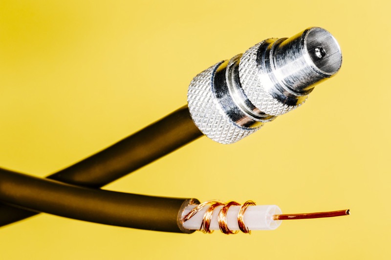 Coaxial Cable With Exposed Copper Center on Yellow Background