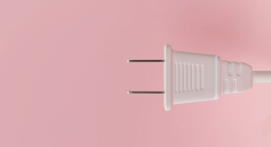 white electrical plug against pink background