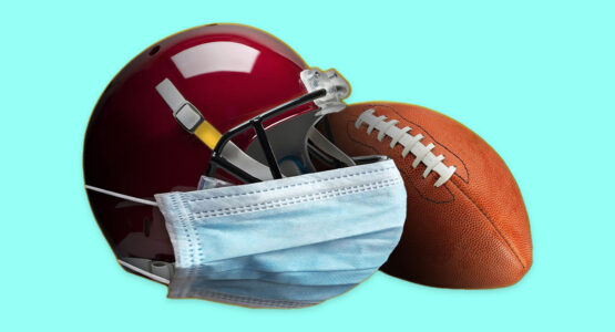 A football and a helmet with a covid mask