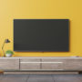 TV on cabinet in modern living room on yellow wall background