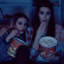Women watching a movie eating popcorn